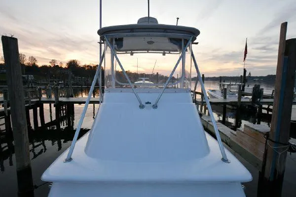 Slide: The Image of 1965 Bertram Sportfisher boat docked at sunset, calm waters, scenic view. - 32