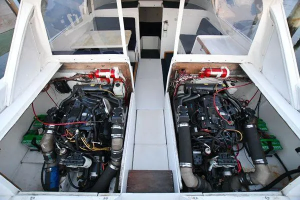 Slide: The Image of 1965 Bertram Sportfisher engine room with dual engines and fire extinguishers. - 33