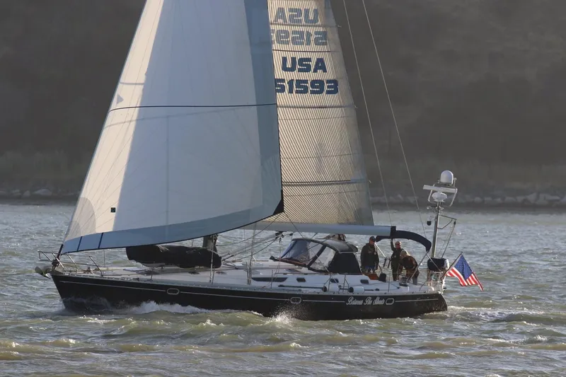 Slide: The Image of Sailing yacht Jeanneau 52.2, 2000 model, cruising on water with American flag. - 1