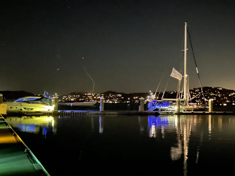 Slide: The Image of Night view of Jeanneau 52.2 sailboat docked, illuminated by colorful lights, 2000 model. - 11