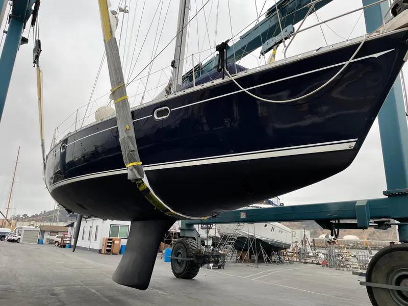 Slide: The Image of 2000 Jeanneau 52.2 sailboat in dry dock, suspended for maintenance. - 15