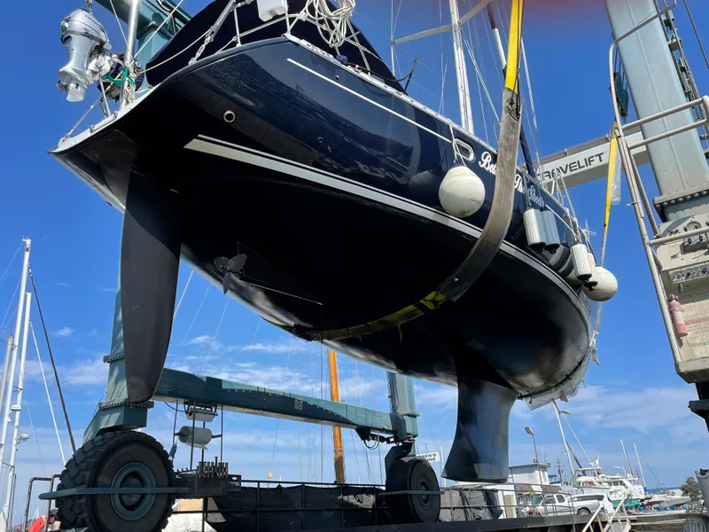 Slide: The Image of Jeanneau 52.2 sailboat from 2000 being lifted in a marina setting. - 16