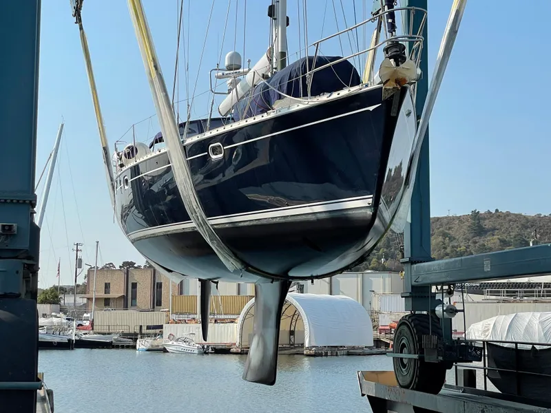 Slide: The Image of Jeanneau 52.2 sailboat from 2000 being lifted in a marina setting. - 17