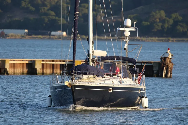Slide: The Image of Sailing yacht Jeanneau 52.2 (2000) navigating near a dock on a sunny day. - 2