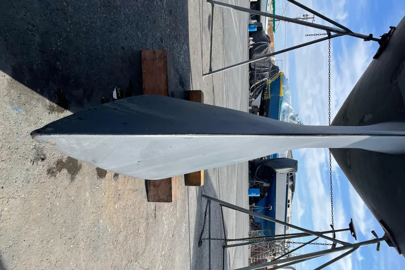 Slide: The Image of Keel of a 2000 Jeanneau 52.2 sailboat on dry dock, supported by stands. - 28