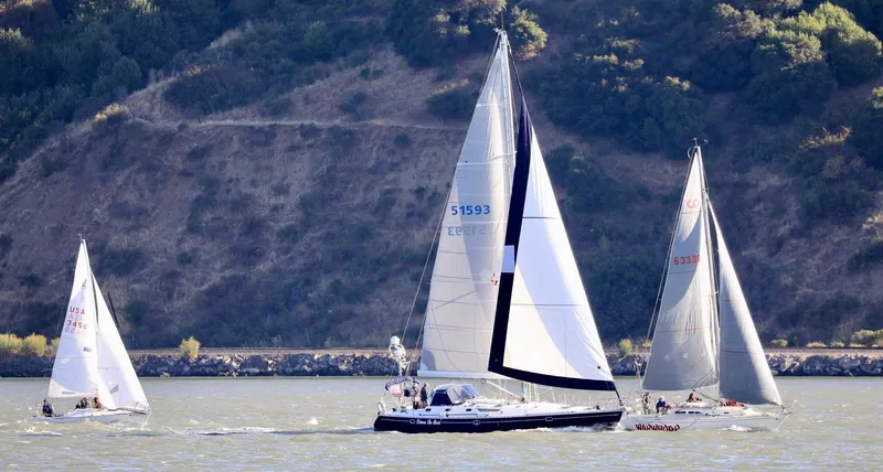 Slide: The Image of Sailboats racing on a sunny day, featuring a 2000 Jeanneau 52.2 model. - 3