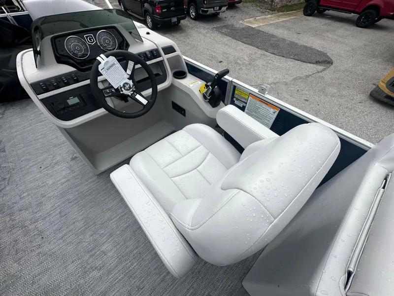 Slide: The Image of 2024 Sweetwater 2286 SB boat cockpit with steering wheel and white captain's chair. - 10
