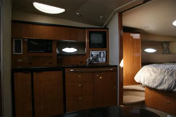 Slide: The Image of 2003 Maxum 3700 SCR yacht interior with kitchenette and cozy bedroom. - 6