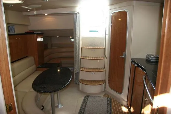 Slide: The Image of 2003 Maxum 3700 SCR yacht interior with seating, table, and stairs. - 9