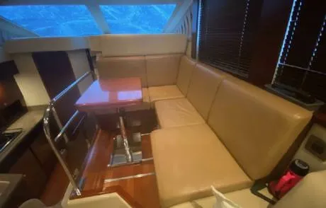 Slide: The Image of Interior of 2007 Sea Ray 36 Sedan Bridge with tan leather seating and wooden table. - 10