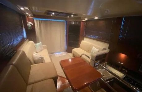 Slide: The Image of Luxurious interior of 2007 Sea Ray 36 Sedan Bridge yacht with plush seating and wooden table. - 11