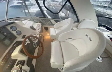 Slide: The Image of 2007 Sea Ray 36 Sedan Bridge helm with leather seats and wooden steering wheel. - 2