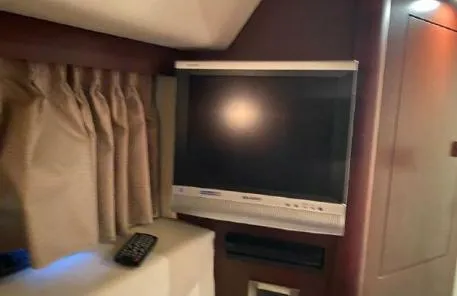 Slide: The Image of 2007 Sea Ray 36 Sedan Bridge interior with TV and remote control. - 22