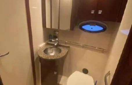 Slide: The Image of 2007 Sea Ray 36 Sedan Bridge bathroom with sink, toilet, and porthole window. - 27