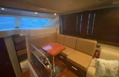 Slide: The Image of Interior of 2007 Sea Ray 36 Sedan Bridge with beige seating and wooden table. - 9