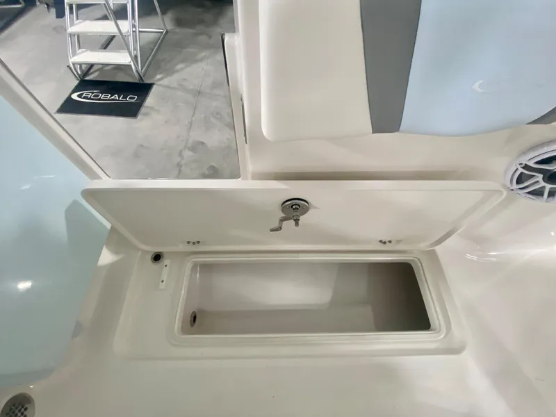 Slide: The Image of 2026 Robalo R250 boat storage compartment with open lid, showcasing interior space. - 13