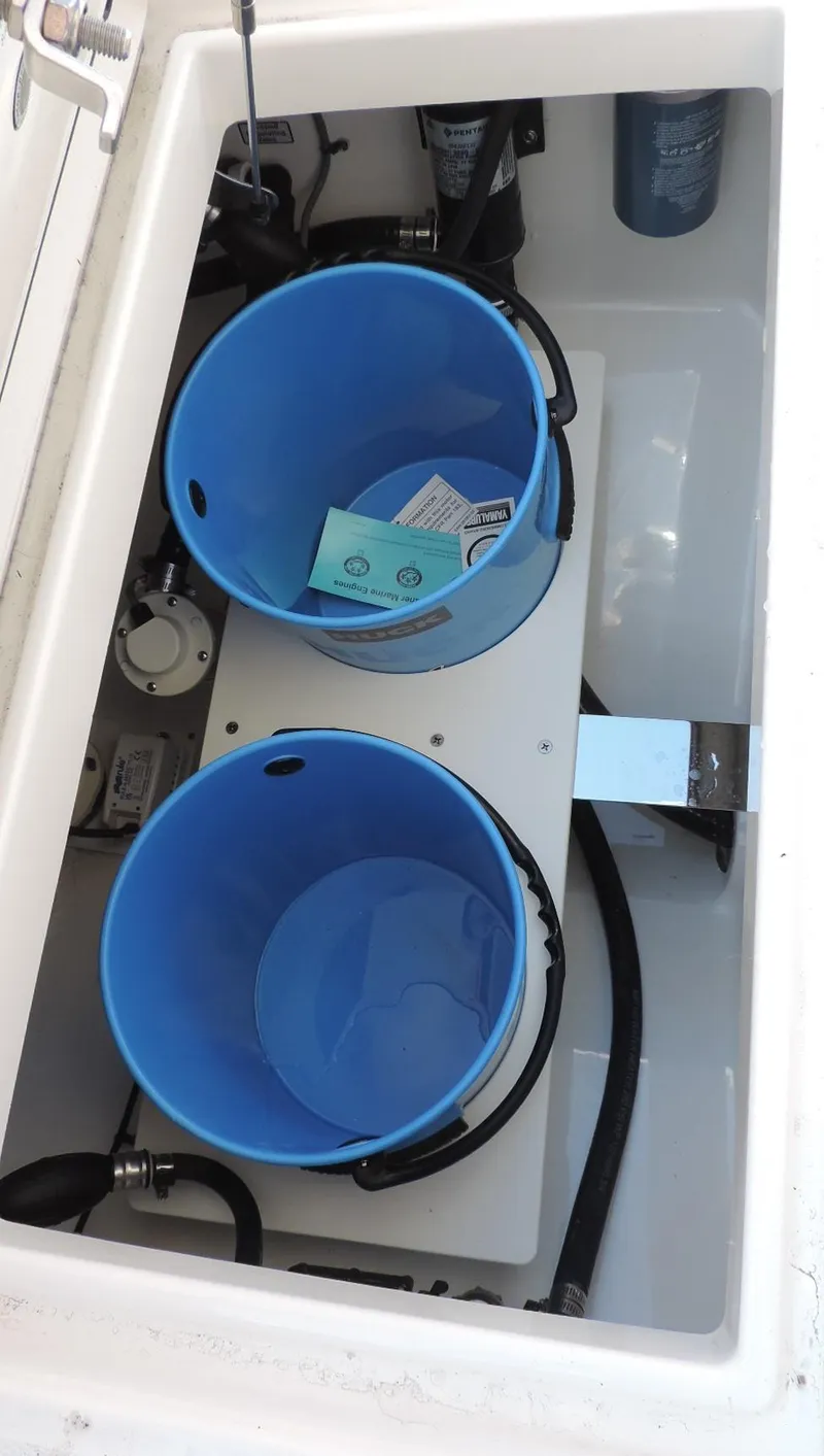 Slide: The Image of 2024 Regulator 23 Center Console storage compartment with blue buckets and accessories. - 14
