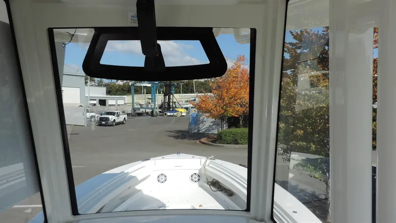 Slide: The Image of 2024 Regulator 23 Center Console boat view from helm, showcasing marina and autumn trees. - 24