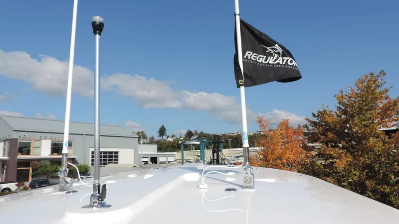 Slide: The Image of 2024 Regulator 23 Center Console boat with flag, clear sky background. - 26