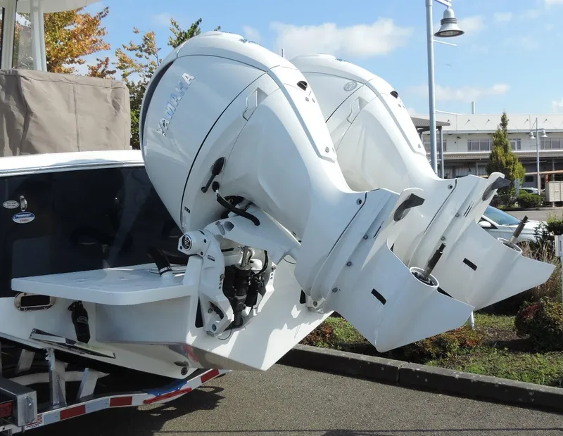 Slide: The Image of 2024 Regulator 23 Center Console with dual outboard engines, parked outdoors. - 4