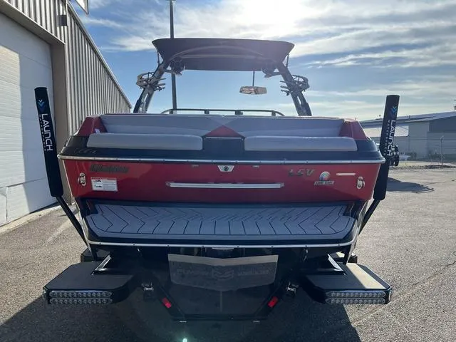 Slide: The Image of 2017 Malibu 23 LSV boat, rear view, red and black, parked outdoors. - 4