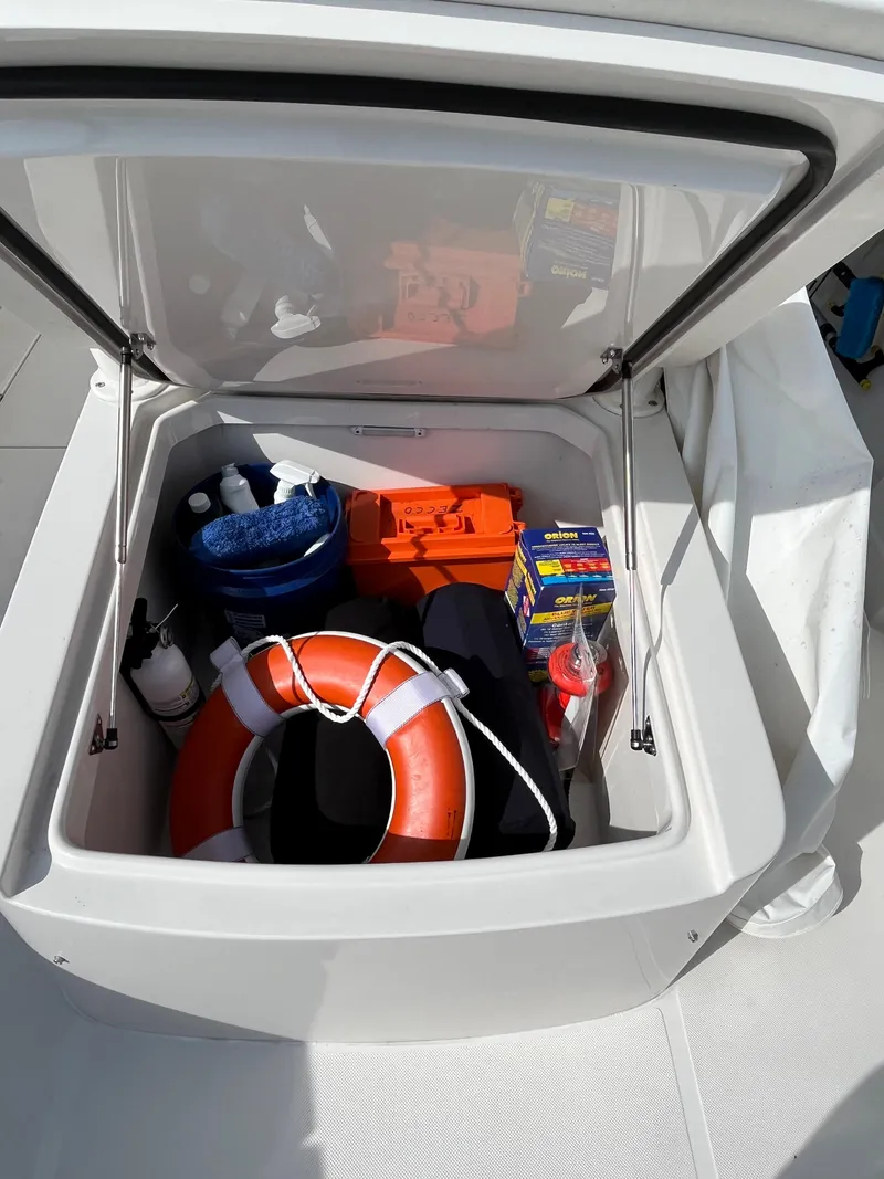 Slide: The Image of Storage compartment of 2020 Jupiter 34 Center Console with safety gear and supplies. - 13