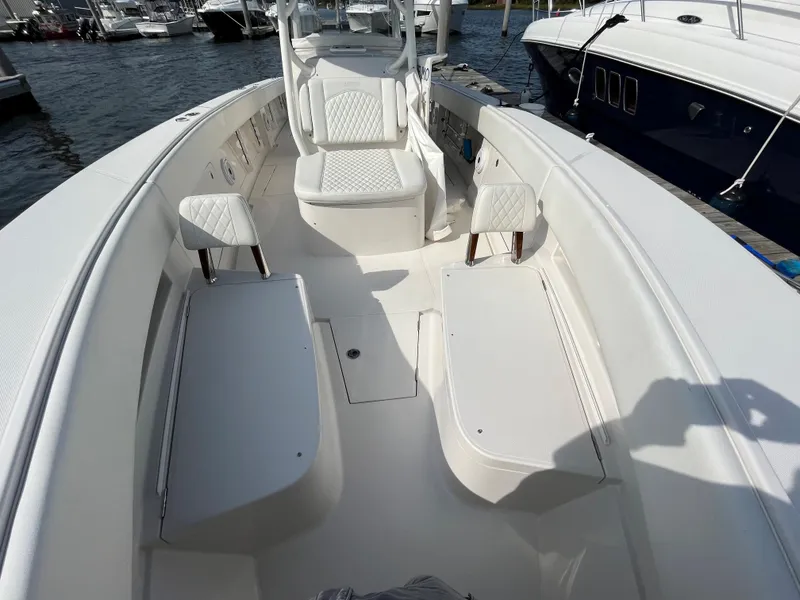 Slide: The Image of 2020 Jupiter 34 Center Console boat interior with white seating and storage compartments. - 14