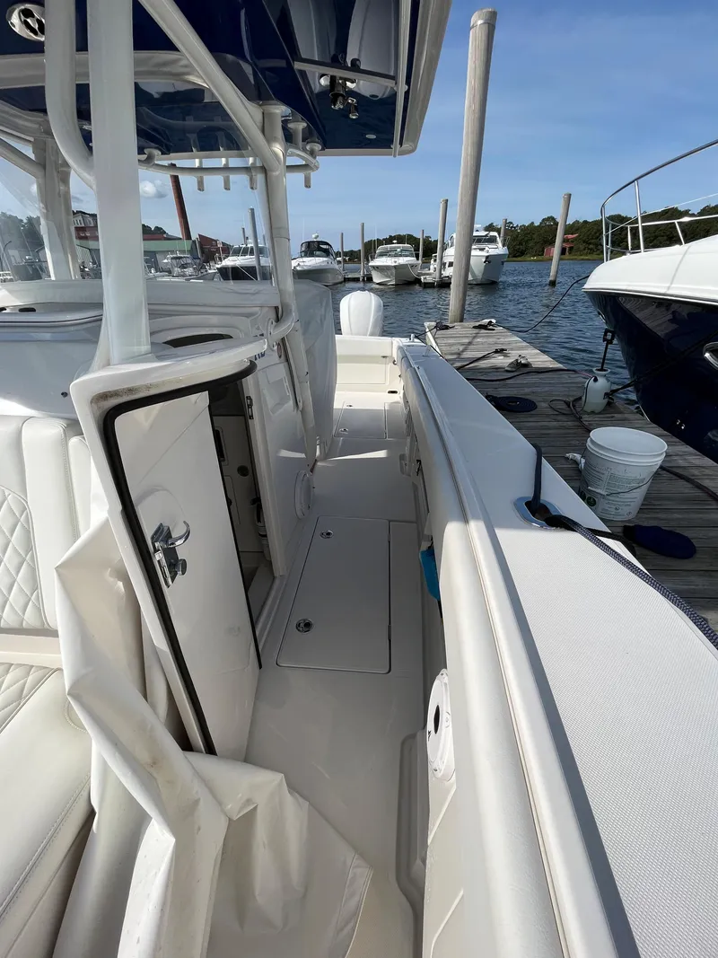 Slide: The Image of 2020 Jupiter 34 Center Console boat docked at marina, featuring sleek white design. - 19