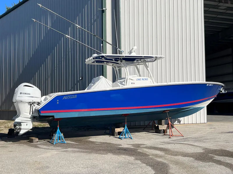 Slide: The Image of 2020 Jupiter 34 Center Console boat in blue, docked on stands. - 2
