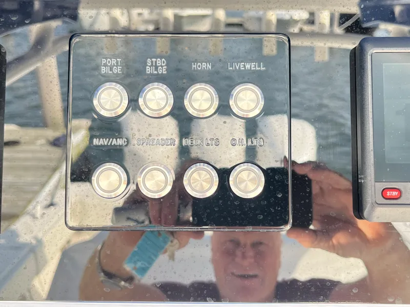 Slide: The Image of Control panel of a 2020 Jupiter 34 Center Console boat with various switches. - 26