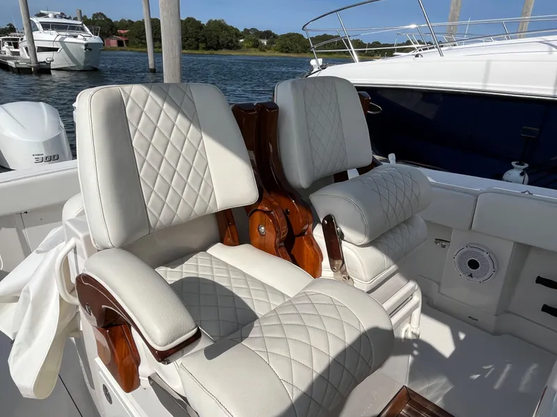Slide: The Image of Luxurious seating on 2020 Jupiter 34 Center Console boat, featuring quilted upholstery and wooden accents. - 28