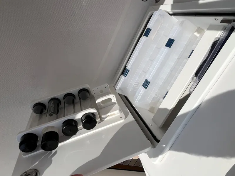 Slide: The Image of Jupiter 34 Center Console 2020 boat storage compartment with organized fishing gear. - 29