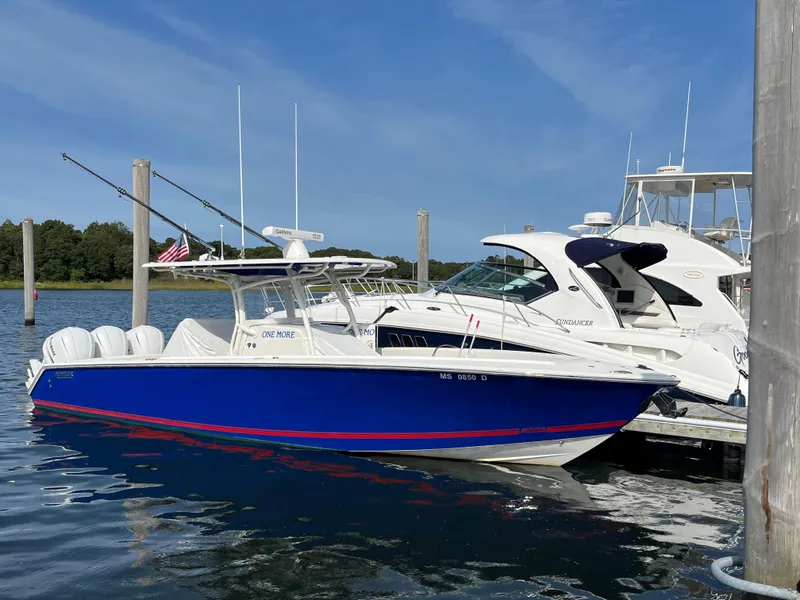 Slide: The Image of 2020 Jupiter 34 Center Console boat docked in marina, blue hull, clear sky. - 3
