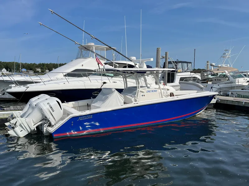 Slide: The Image of 2020 Jupiter 34 Center Console boat docked in marina, blue hull, twin engines. - 4