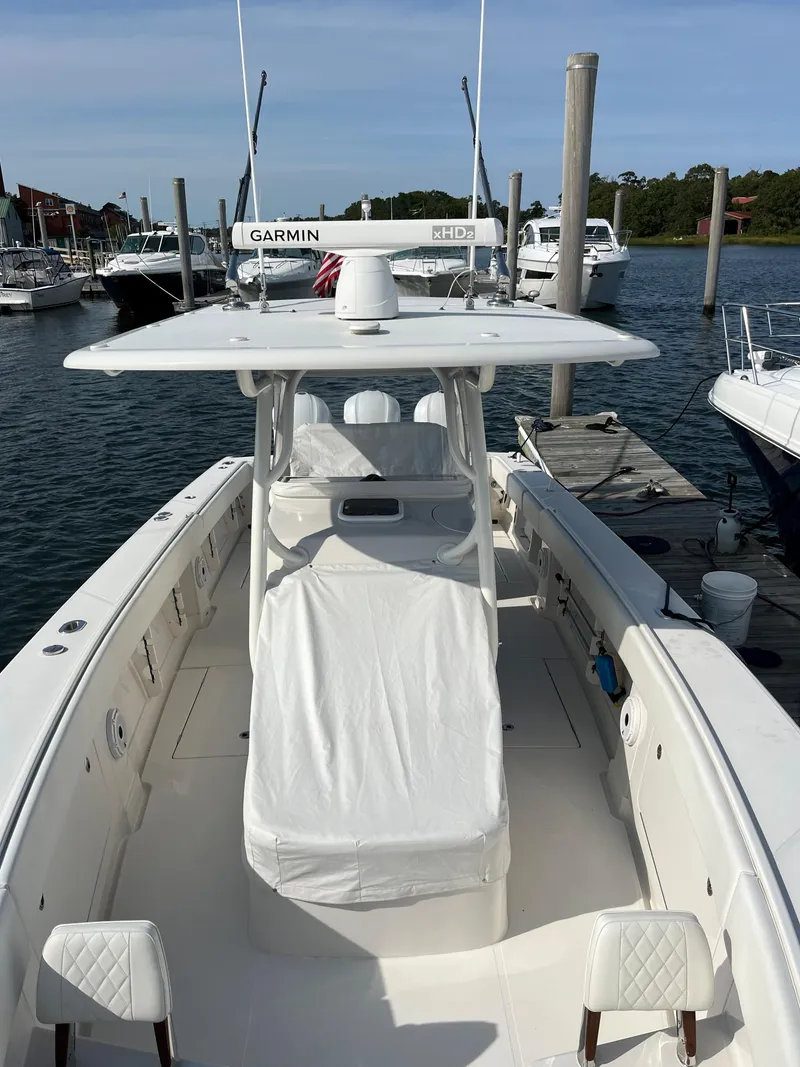 Slide: The Image of 2020 Jupiter 34 Center Console boat docked at marina, featuring Garmin equipment. - 47