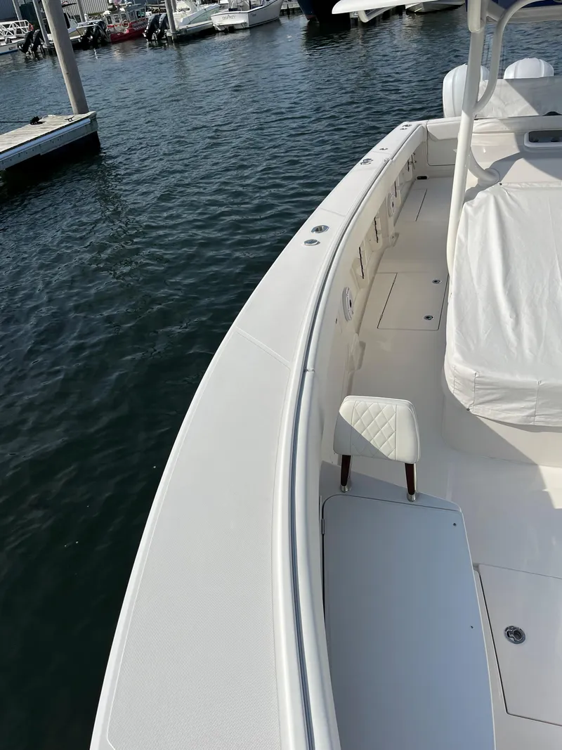 Slide: The Image of 2020 Jupiter 34 Center Console boat docked in marina, showcasing sleek design and spacious deck. - 49