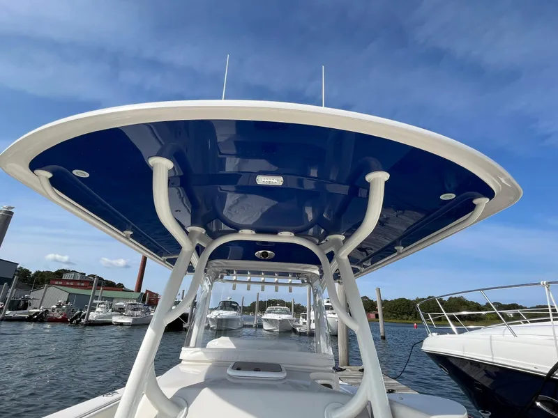 Slide: The Image of 2020 Jupiter 34 Center Console boat docked, featuring a sleek blue canopy. - 5