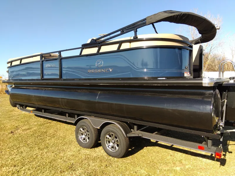 Slide: The Image of 2024 Regency 250 LE3 pontoon boat on a trailer. - 2