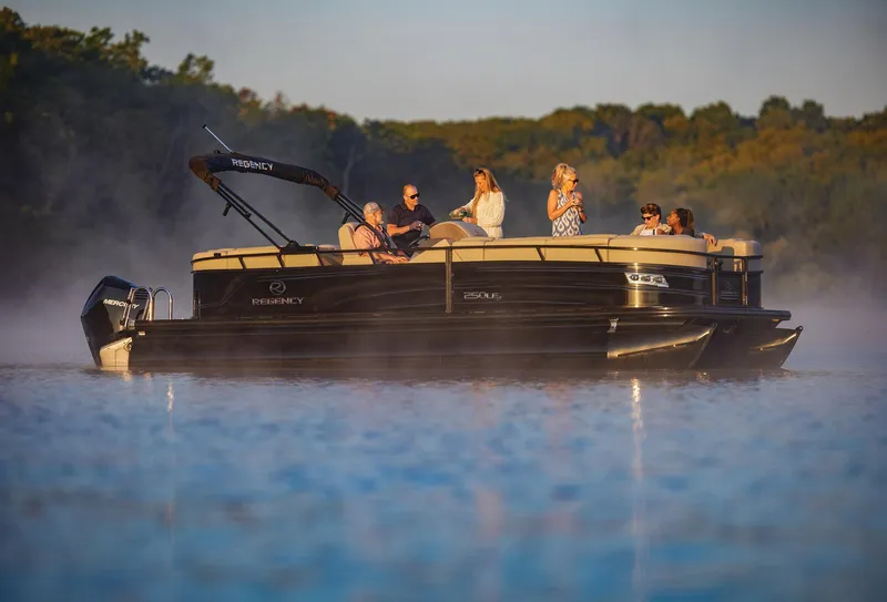 Slide: The Image of 2024 Regency 250 LE3 pontoon boat cruising on a serene lake with passengers. - 21