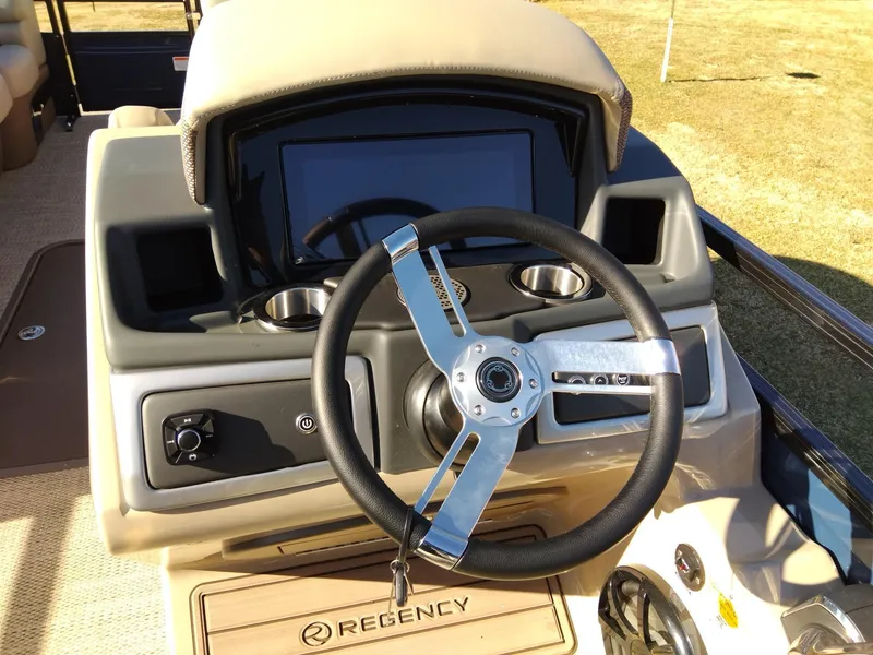 Slide: The Image of 2024 Regency 250 LE3 boat dashboard with steering wheel and control panel. - 8