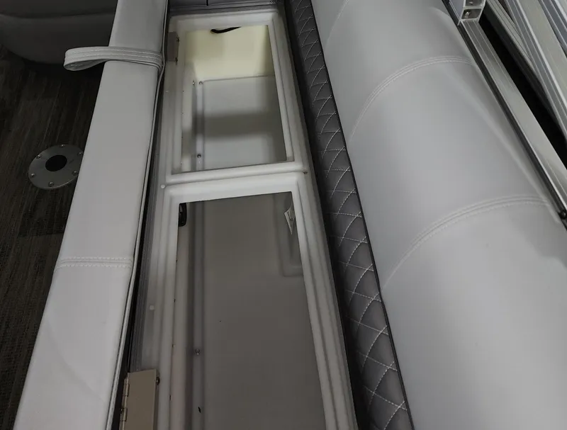 Slide: The Image of 2024 Ranger Reata 220C boat interior storage compartment with cushioned seating. - 13