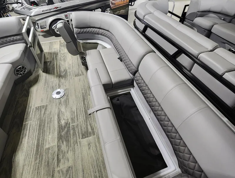 Slide: The Image of 2024 Ranger Reata 220C pontoon boat interior with gray seating and storage compartments. - 3