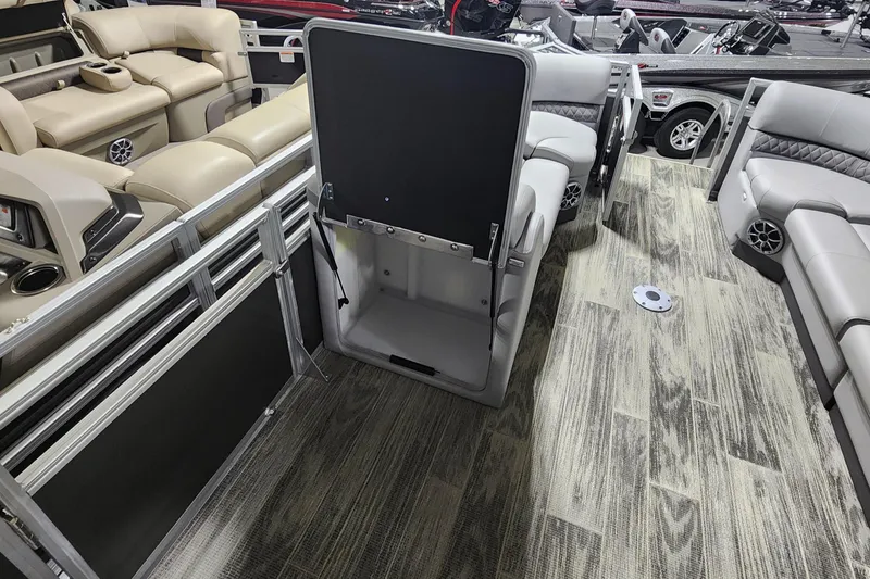 Slide: The Image of 2024 Ranger Reata 220C pontoon boat interior with open storage compartment and seating. - 6