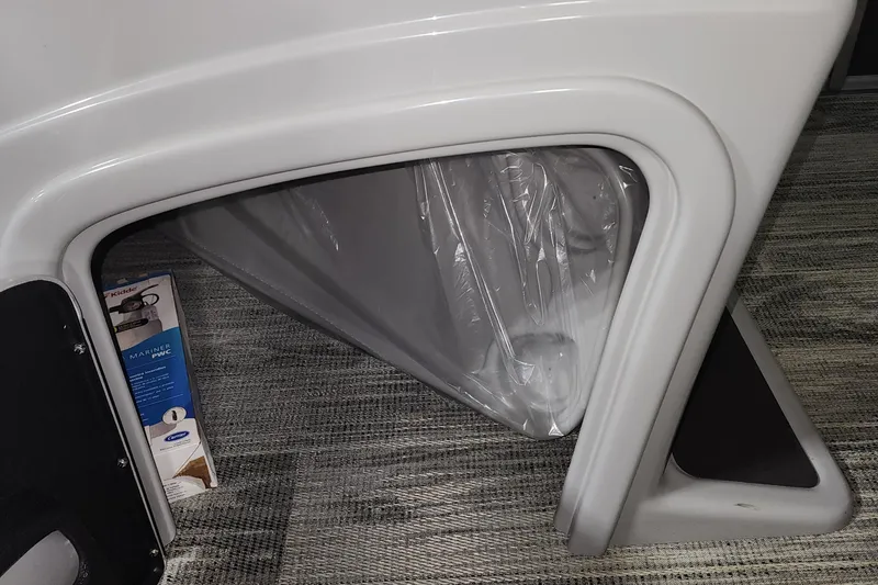 Slide: The Image of 2024 Ranger Reata 220C storage compartment with plastic cover and carpeted flooring. - 8