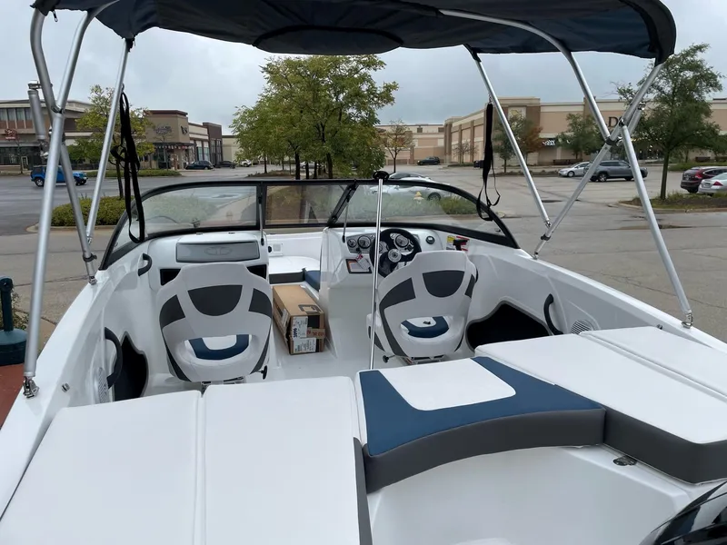 Slide: The Image of 2024 Tahoe 185 S boat interior with seating and dashboard in a parking lot. - 4