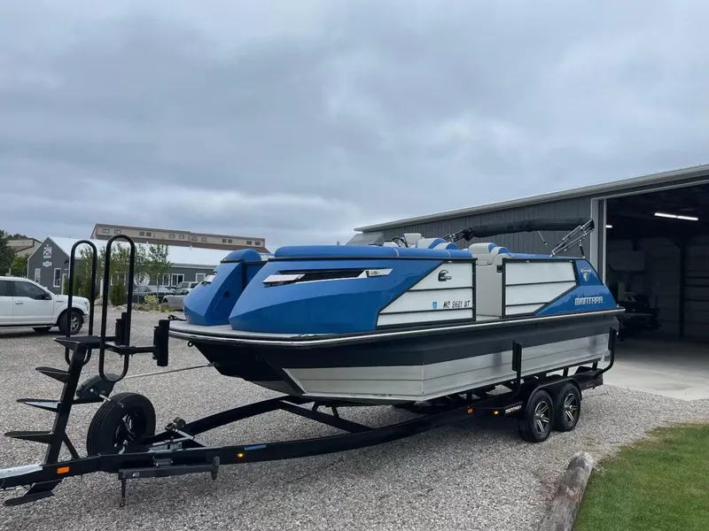Slide: The Image of 2021 Montara 23' Surfboss boat on trailer, parked outdoors. - 2