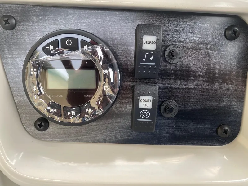 Slide: The Image of 2024 Starcraft LX 20 R control panel with stereo and court lights switches. - 13