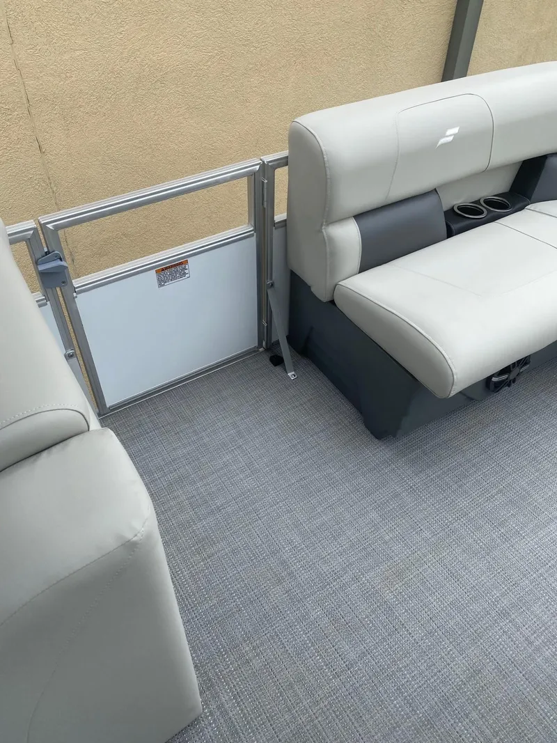 Slide: The Image of 2024 Starcraft LX 20 R pontoon boat interior with gray seating and carpet. - 16