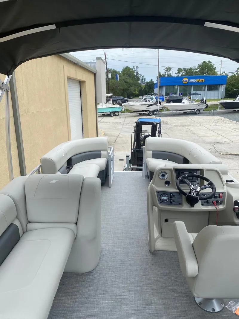 Slide: The Image of 2024 Starcraft LX 20 R pontoon boat interior with plush seating and modern dashboard. - 8