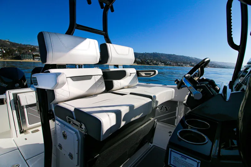 Slide: The Image of 2023 Blackfin 272 CC boat interior with white seating and steering console on a sunny day. - 10